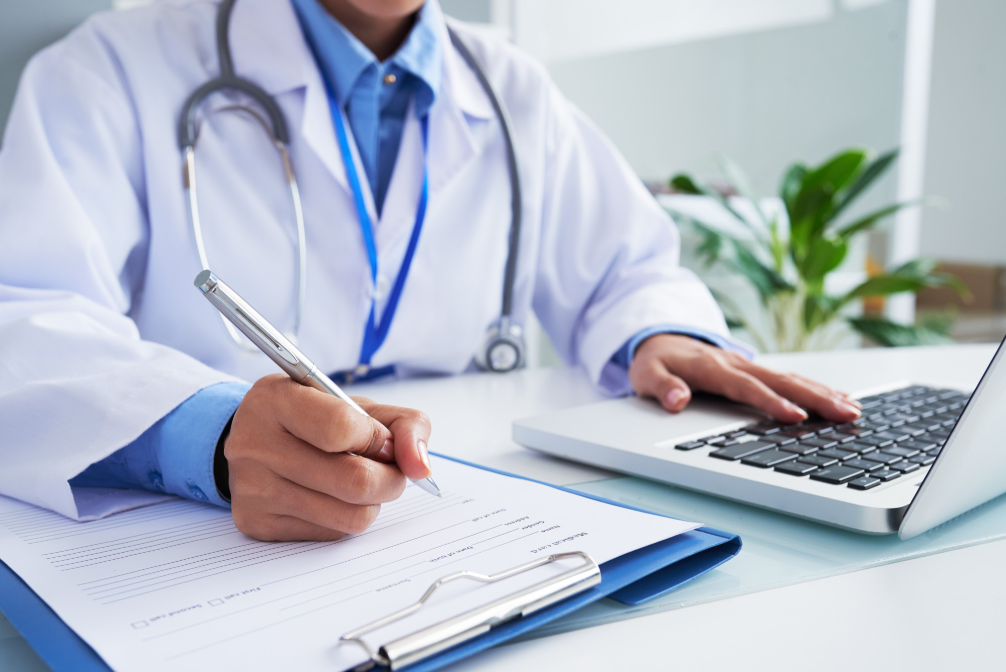 Doctor con documentos y computadora